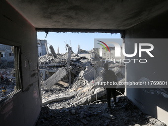 Palestinians gather on the rubble of a house destroyed in an Israeli strike at the Nuseirat refugee camp in the central Gaza Strip on Novemb...