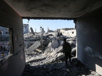 Palestinians gather on the rubble of a house destroyed in an Israeli strike at the Nuseirat refugee camp in the central Gaza Strip on Novemb...