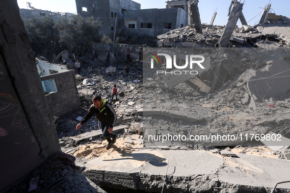 Palestinians gather on the rubble of a house destroyed in an Israeli strike at the Nuseirat refugee camp in the central Gaza Strip on Novemb...