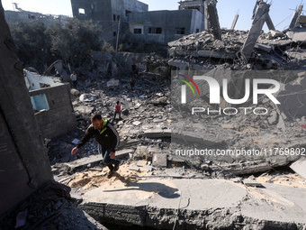 Palestinians gather on the rubble of a house destroyed in an Israeli strike at the Nuseirat refugee camp in the central Gaza Strip on Novemb...