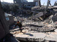 Palestinians gather on the rubble of a house destroyed in an Israeli strike at the Nuseirat refugee camp in the central Gaza Strip on Novemb...