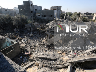 Palestinians gather on the rubble of a house destroyed in an Israeli strike at the Nuseirat refugee camp in the central Gaza Strip on Novemb...