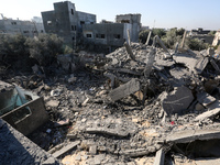 Palestinians gather on the rubble of a house destroyed in an Israeli strike at the Nuseirat refugee camp in the central Gaza Strip on Novemb...