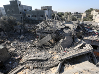 Palestinians gather on the rubble of a house destroyed in an Israeli strike at the Nuseirat refugee camp in the central Gaza Strip on Novemb...