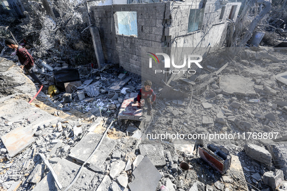 A Palestinian boy walks on the rubble of a house destroyed in an Israeli strike at the Nuseirat refugee camp in the central Gaza Strip on No...