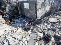 A Palestinian boy walks on the rubble of a house destroyed in an Israeli strike at the Nuseirat refugee camp in the central Gaza Strip on No...