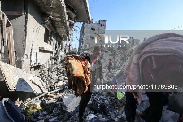 Palestinians gather on the rubble of a house destroyed in an Israeli strike at the Nuseirat refugee camp in the central Gaza Strip on Novemb...