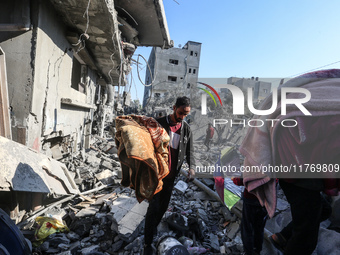 Palestinians gather on the rubble of a house destroyed in an Israeli strike at the Nuseirat refugee camp in the central Gaza Strip on Novemb...