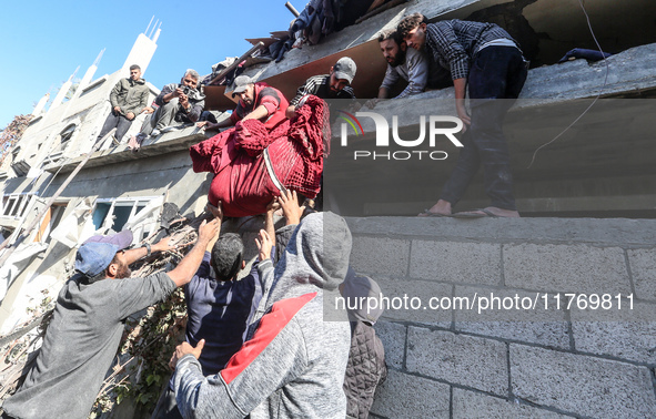 A body of a Palestinian is retrieved from the rubble of a house destroyed in an Israeli strike at the Nuseirat refugee camp in the central G...