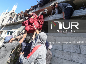 A body of a Palestinian is retrieved from the rubble of a house destroyed in an Israeli strike at the Nuseirat refugee camp in the central G...