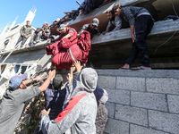 A body of a Palestinian is retrieved from the rubble of a house destroyed in an Israeli strike at the Nuseirat refugee camp in the central G...