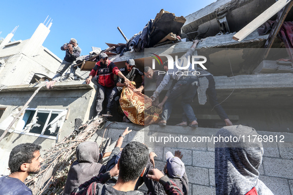 A body of a Palestinian is retrieved from the rubble of a house destroyed in an Israeli strike at the Nuseirat refugee camp in the central G...