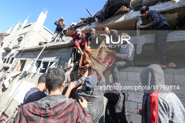 A body of a Palestinian is retrieved from the rubble of a house destroyed in an Israeli strike at the Nuseirat refugee camp in the central G...