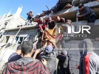 A body of a Palestinian is retrieved from the rubble of a house destroyed in an Israeli strike at the Nuseirat refugee camp in the central G...