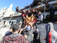 A body of a Palestinian is retrieved from the rubble of a house destroyed in an Israeli strike at the Nuseirat refugee camp in the central G...