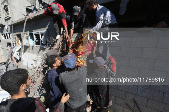 A body of a Palestinian is retrieved from the rubble of a house destroyed in an Israeli strike at the Nuseirat refugee camp in the central G...