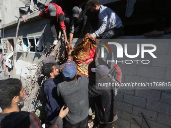 A body of a Palestinian is retrieved from the rubble of a house destroyed in an Israeli strike at the Nuseirat refugee camp in the central G...