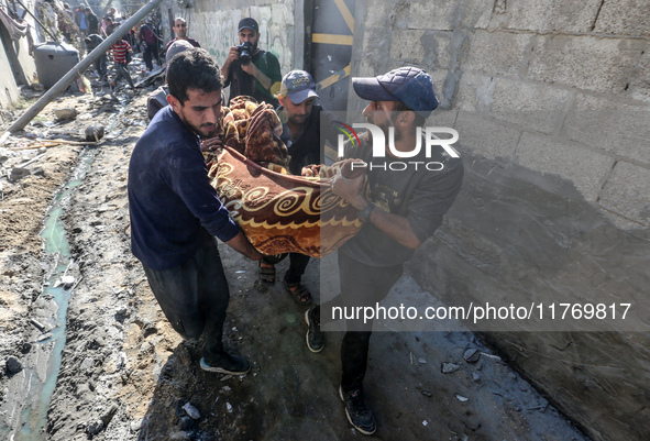 A body of a Palestinian is retrieved from the rubble of a house destroyed in an Israeli strike at the Nuseirat refugee camp in the central G...