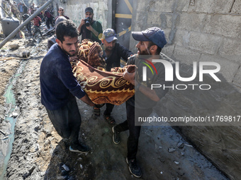 A body of a Palestinian is retrieved from the rubble of a house destroyed in an Israeli strike at the Nuseirat refugee camp in the central G...