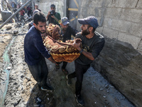 A body of a Palestinian is retrieved from the rubble of a house destroyed in an Israeli strike at the Nuseirat refugee camp in the central G...