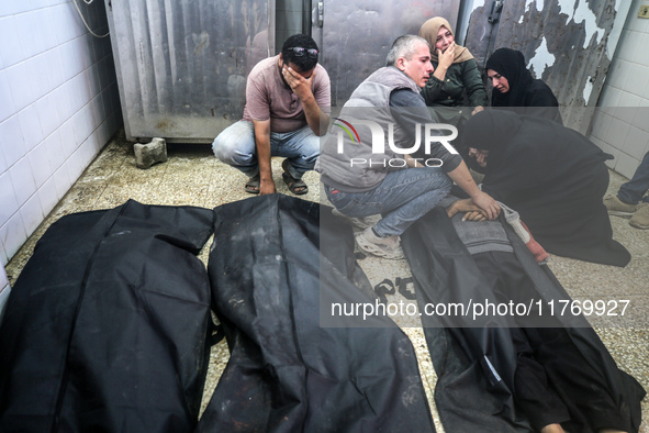 People react next to the bodies of Palestinians killed in an Israeli airstrike at the Al-Aqsa Martyrs Hospital in Deir al-Balah, central Gaz...