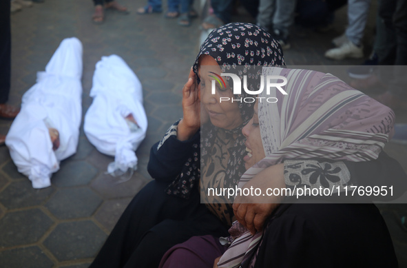 People react next to the bodies of Palestinians killed in an Israeli airstrike at the Al-Aqsa Martyrs Hospital in Deir al-Balah, central Gaz...