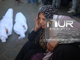 People react next to the bodies of Palestinians killed in an Israeli airstrike at the Al-Aqsa Martyrs Hospital in Deir al-Balah, central Gaz...