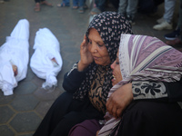 People react next to the bodies of Palestinians killed in an Israeli airstrike at the Al-Aqsa Martyrs Hospital in Deir al-Balah, central Gaz...