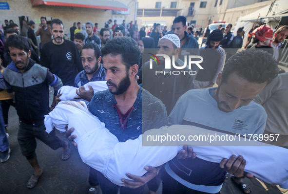 People carry the bodies of two children killed in an Israeli airstrike to the Al-Aqsa Martyrs Hospital in Deir al-Balah, central Gaza Strip,...