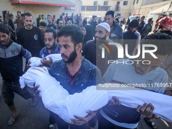 People carry the bodies of two children killed in an Israeli airstrike to the Al-Aqsa Martyrs Hospital in Deir al-Balah, central Gaza Strip,...