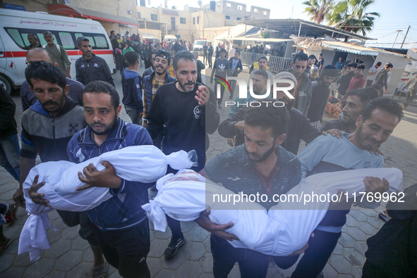 People carry the bodies of two children killed in an Israeli airstrike to the Al-Aqsa Martyrs Hospital in Deir al-Balah, central Gaza Strip,...