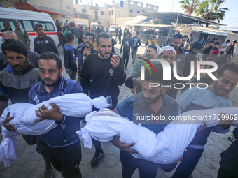 People carry the bodies of two children killed in an Israeli airstrike to the Al-Aqsa Martyrs Hospital in Deir al-Balah, central Gaza Strip,...