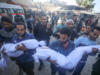 People carry the bodies of two children killed in an Israeli airstrike to the Al-Aqsa Martyrs Hospital in Deir al-Balah, central Gaza Strip,...