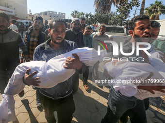 People carry the bodies of two children killed in an Israeli airstrike to the Al-Aqsa Martyrs Hospital in Deir al-Balah, central Gaza Strip,...