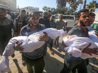 People carry the bodies of two children killed in an Israeli airstrike to the Al-Aqsa Martyrs Hospital in Deir al-Balah, central Gaza Strip,...