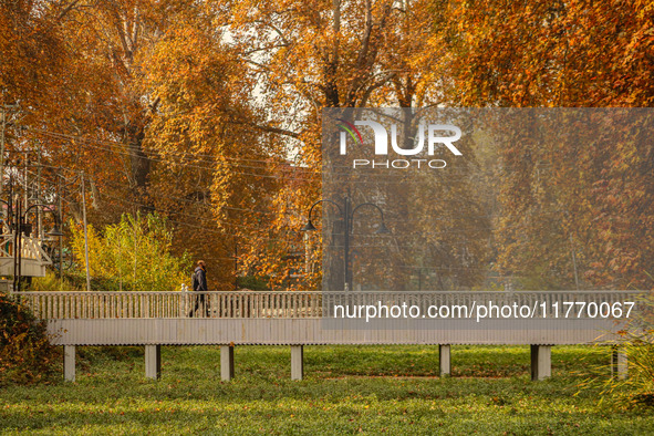 A man walks over a wooden bridge during an autumn day in Srinagar, Jammu and Kashmir, on November 12, 2024. Autumn, locally known as Harud,...