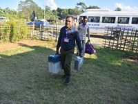 An election official carries electronic materials to a polling station on the eve of the Assam state assembly by-elections in Samaguri, Naga...