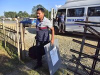 An election official carries electronic materials to a polling station on the eve of the Assam state assembly by-elections in Samaguri, Naga...