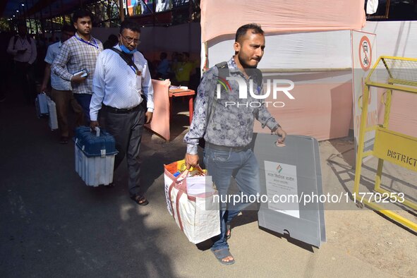 Officials carry Electronic Voting Machines (EVM) to their polling stations on the eve of Assam state assembly by-elections in Nagaon Distric...