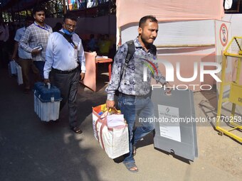 Officials carry Electronic Voting Machines (EVM) to their polling stations on the eve of Assam state assembly by-elections in Nagaon Distric...