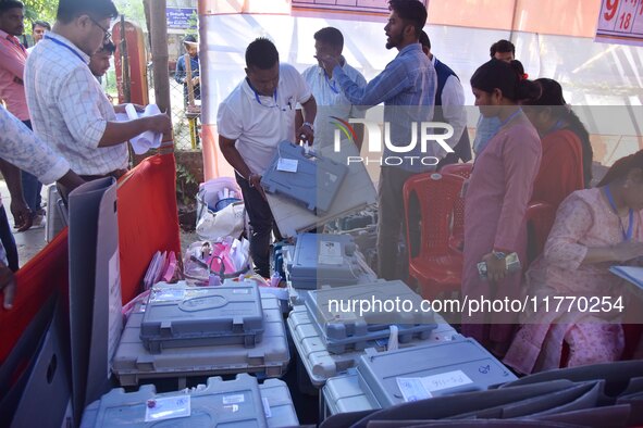 Election officials check Electronic Voting Machines (EVMs) and other polling materials at a distribution center in Nagaon District, Assam, I...