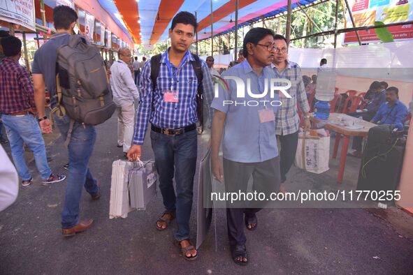 Officials carry Electronic Voting Machines (EVM) to their polling stations on the eve of Assam state assembly by-elections in Nagaon Distric...