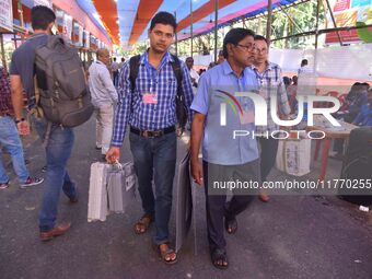 Officials carry Electronic Voting Machines (EVM) to their polling stations on the eve of Assam state assembly by-elections in Nagaon Distric...