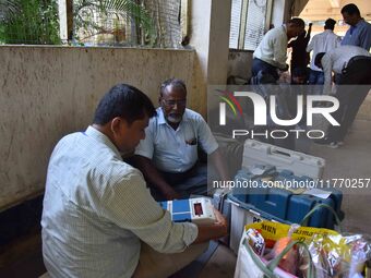 Polling officials check Electronic Voting Machines (EVMs) and other polling materials after receiving them from a distribution center on the...