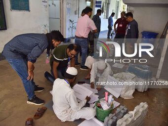 Polling officials check Electronic Voting Machines (EVMs) and other polling materials after receiving them from a distribution center on the...