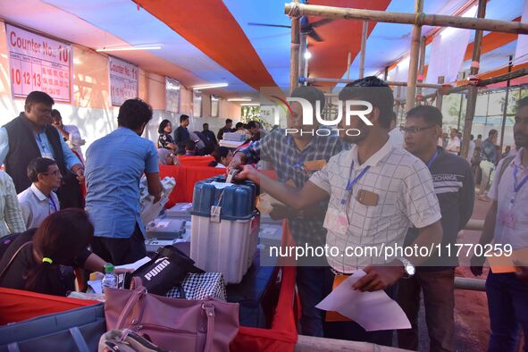 Polling officials receive Electronic Voting Machines (EVMs) and other polling materials from a distribution center in Nagaon District, Assam...