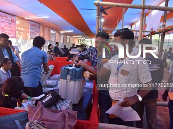 Polling officials receive Electronic Voting Machines (EVMs) and other polling materials from a distribution center in Nagaon District, Assam...