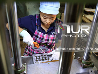 A worker produces metal parts at a workshop of a precision machinery manufacturing enterprise in Binzhou, China, on November 12, 2024. (