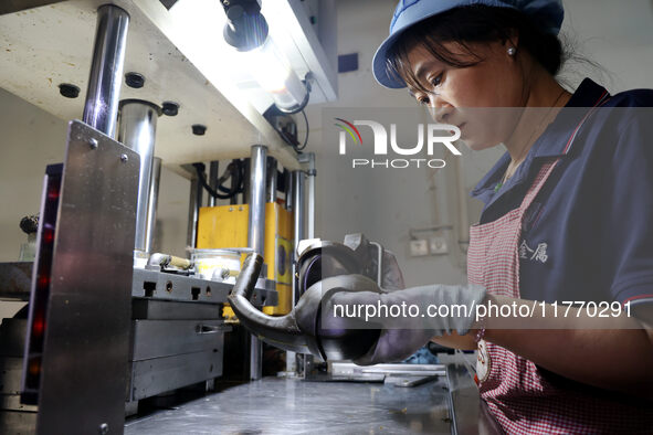 A worker produces metal parts at a workshop of a precision machinery manufacturing enterprise in Binzhou, China, on November 12, 2024. 