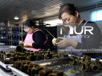 A worker produces metal parts at a workshop of a precision machinery manufacturing enterprise in Binzhou, China, on November 12, 2024. (